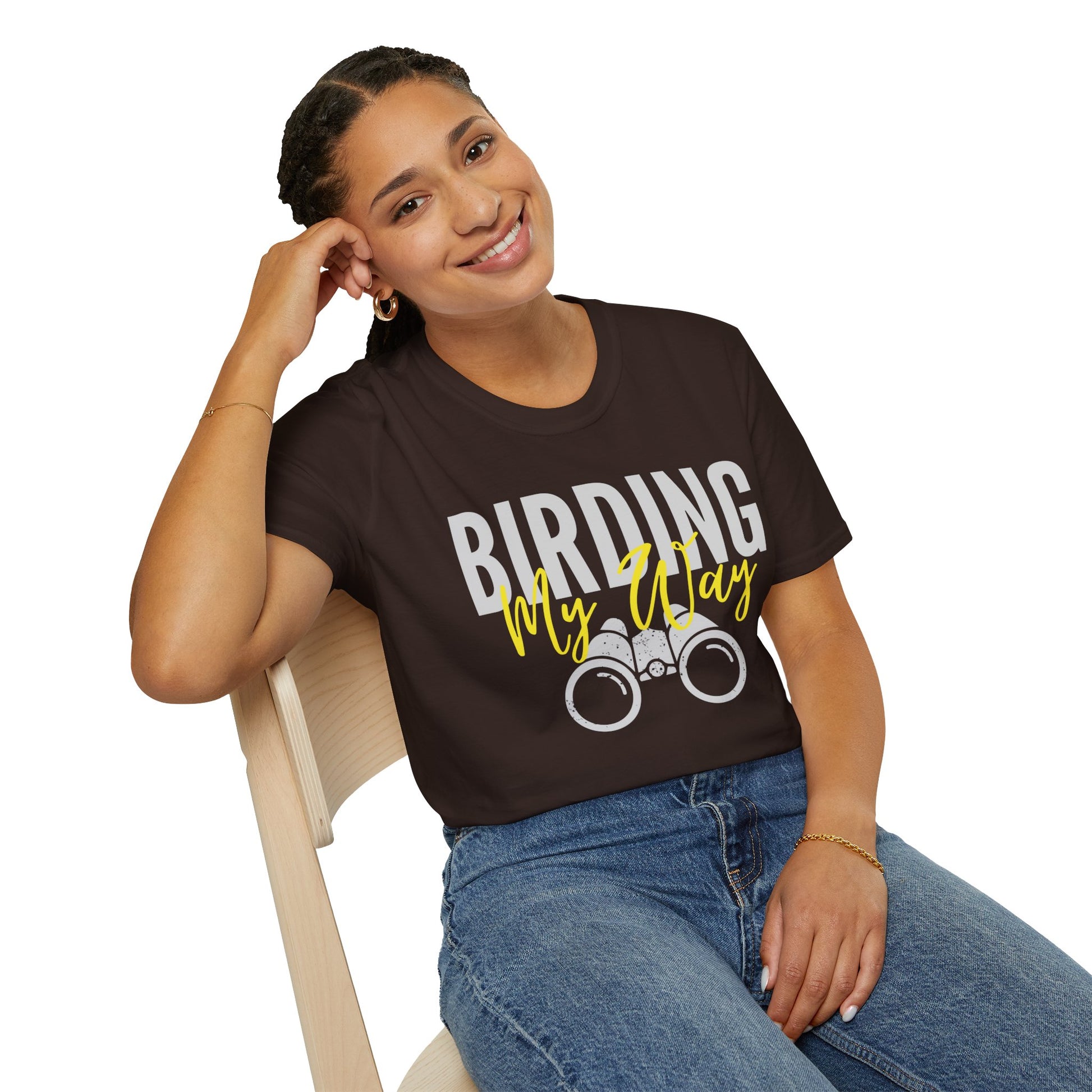 Woman wearing brown 'Birding My Way' t-shirt with vintage binoculars graphic, sitting on a chair — birdwatching enthusiast gift tee