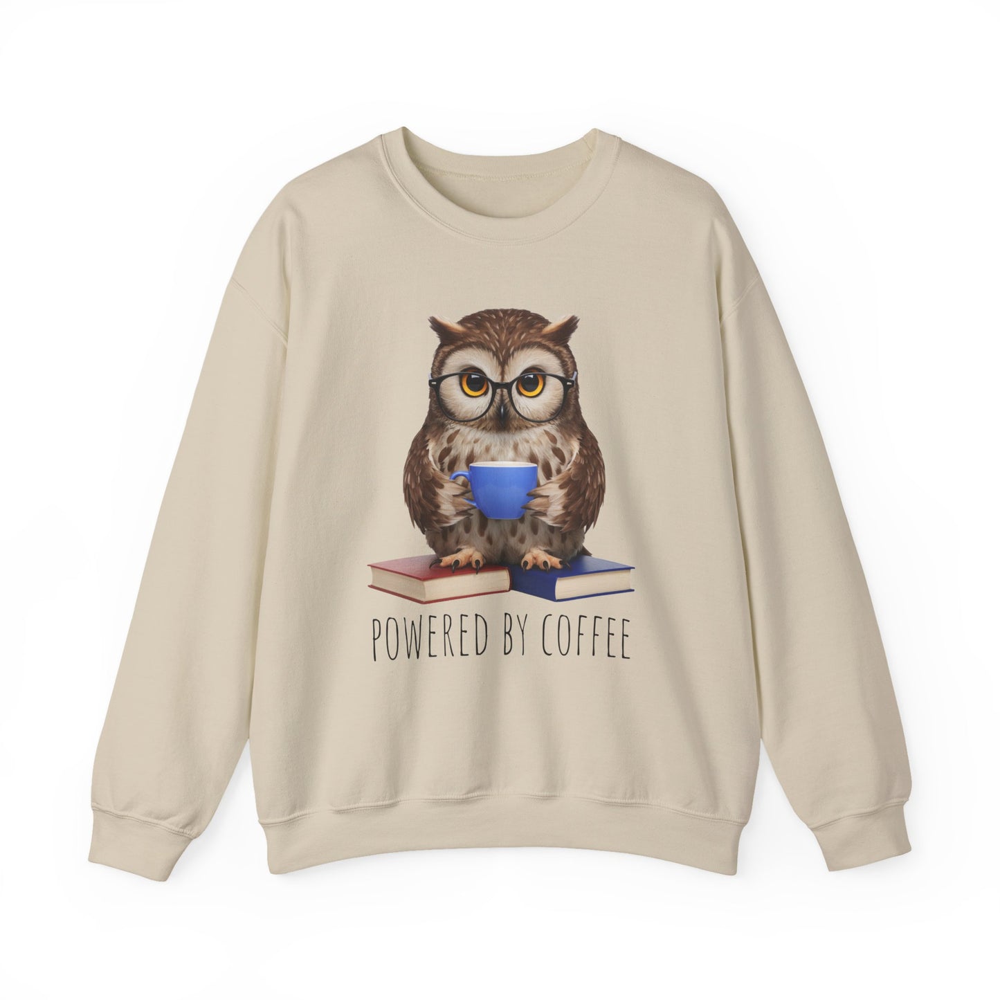 Beige sweatshirt with an owl graphic holding a coffee cup and books, text 'Powered by Coffee' on a white background.