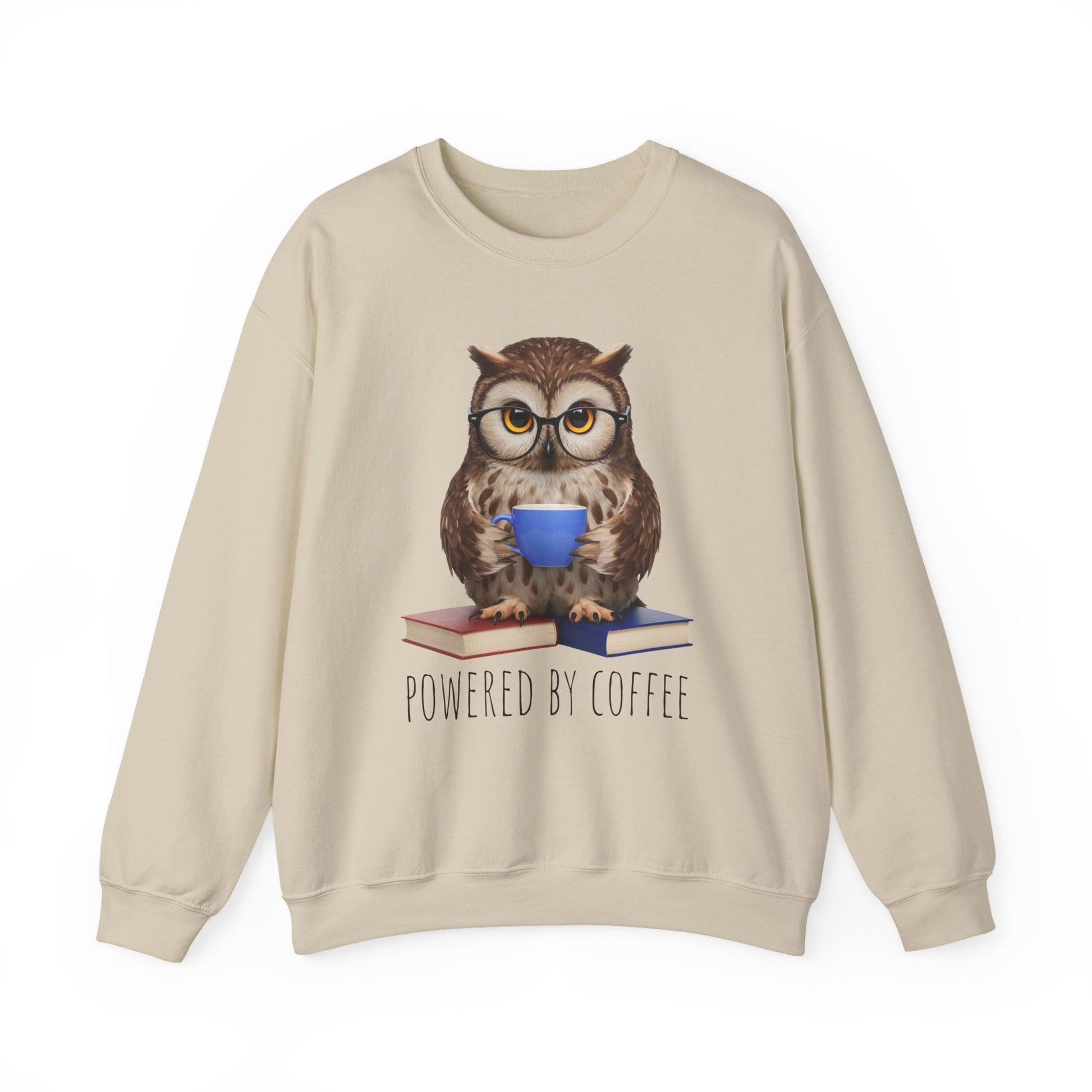 Beige sweatshirt with an owl graphic holding a coffee cup and books, text 'Powered by Coffee' on a white background.
