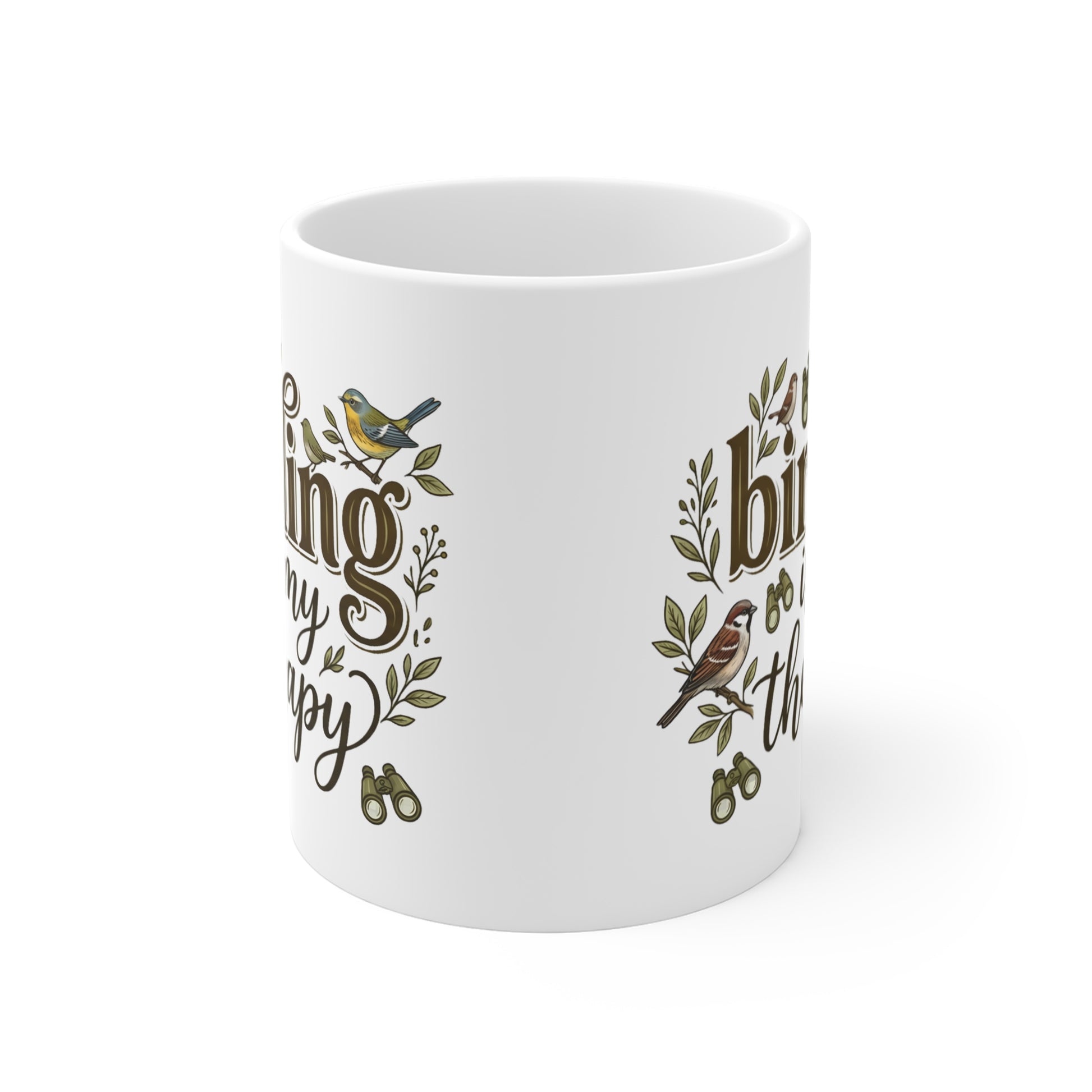 A white ceramic mug featuring a printed design with brown cursive text, green leaves, and small birds, shown on a clean white background.