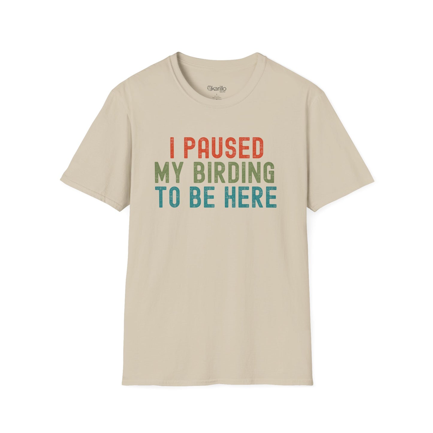 Front view of sand color t-shirt with colorful text 'I PAUSED MY BIRDING TO BE HERE' on a white background