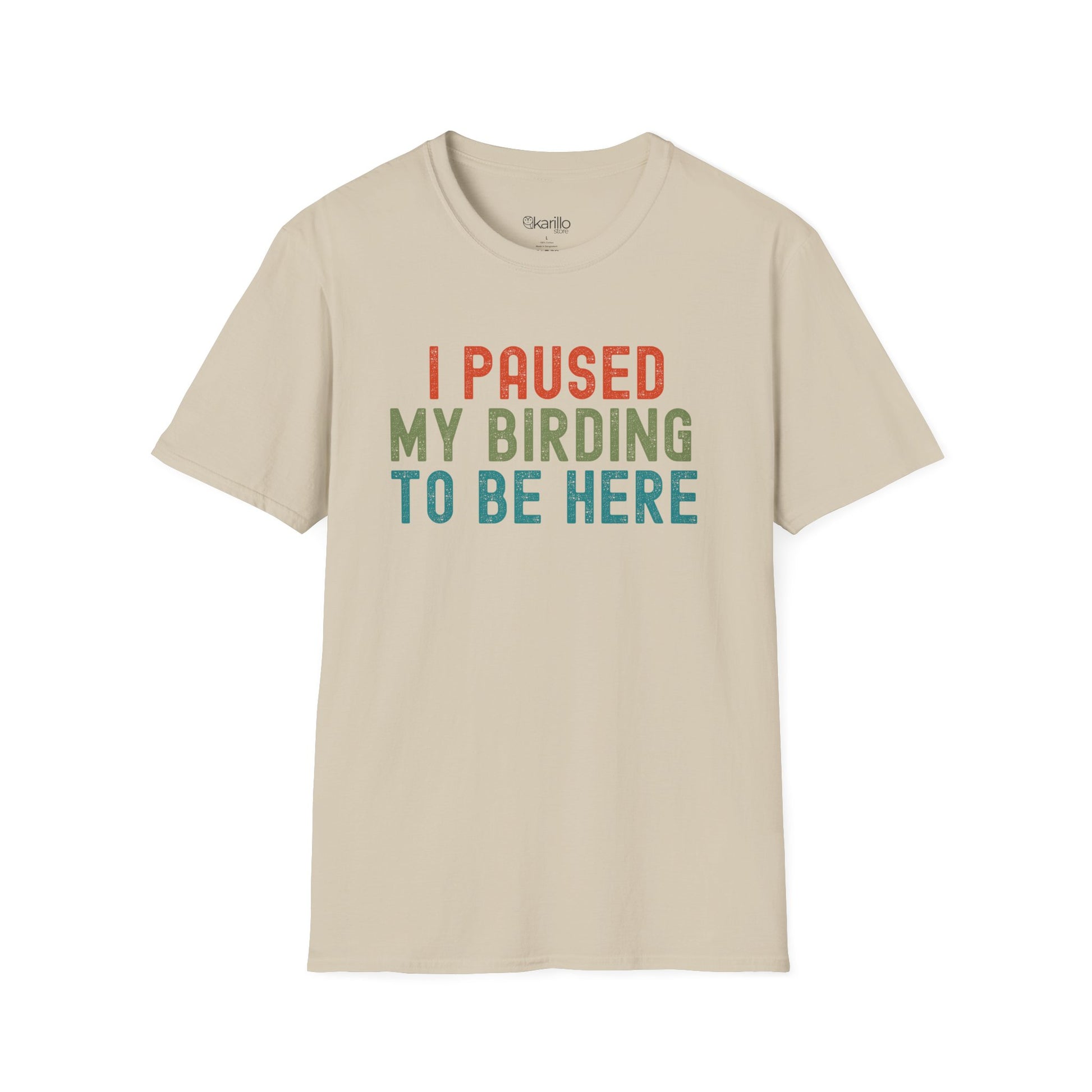 Front view of sand color t-shirt with colorful text 'I PAUSED MY BIRDING TO BE HERE' on a white background